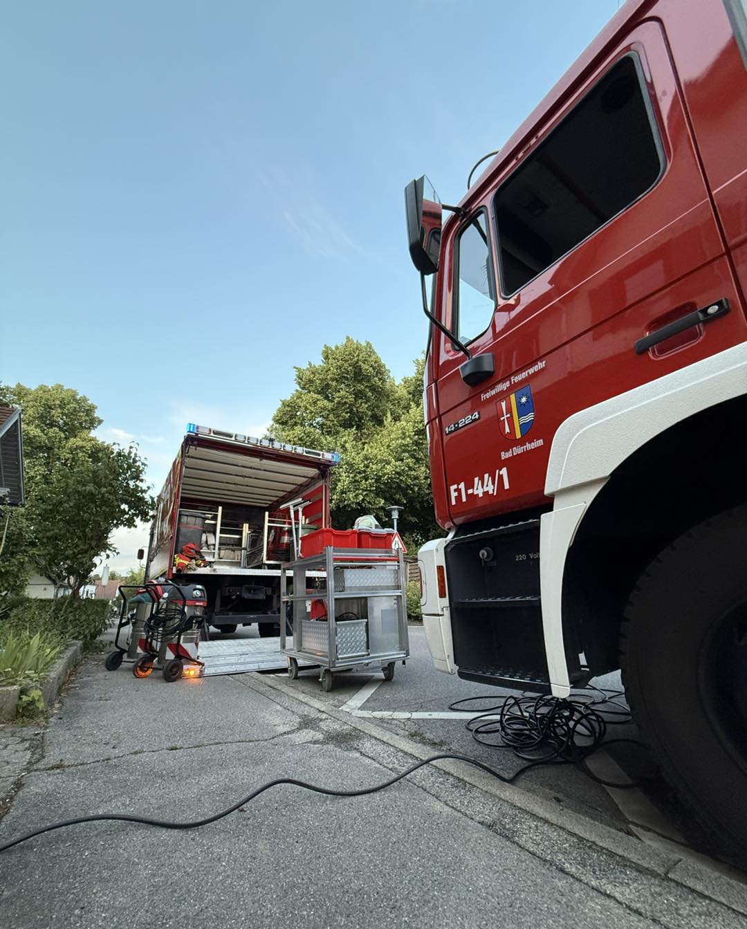 Rüstwagen mit geöffnetem Geräteraum und Pumpe an der Einsatzstelle