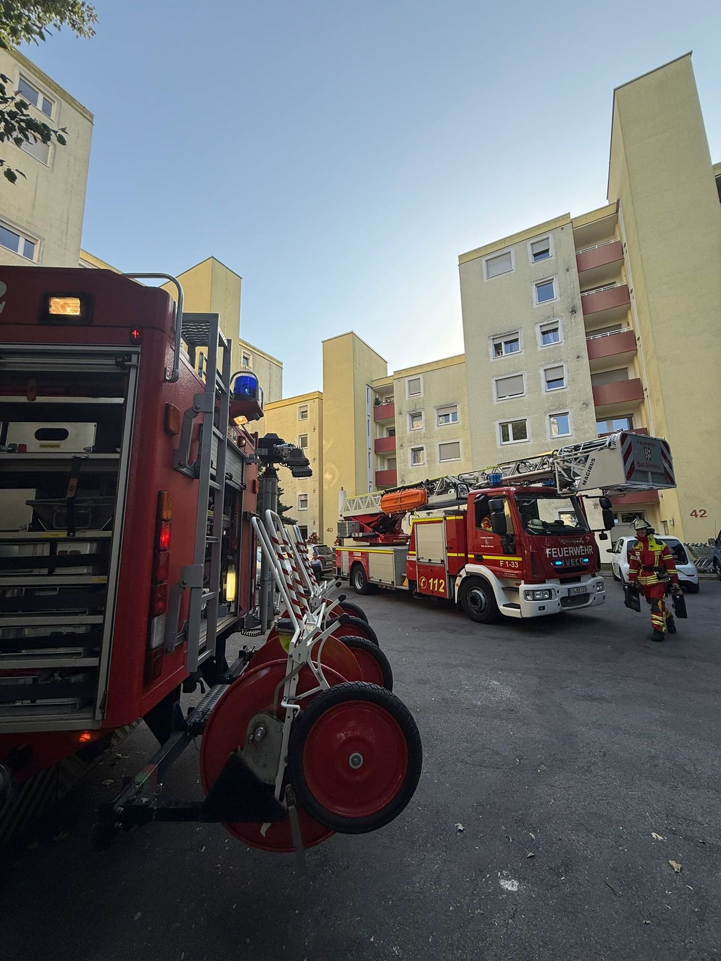 Löschfahrzeug und Drehleiter vor einem Wohnhochhaus